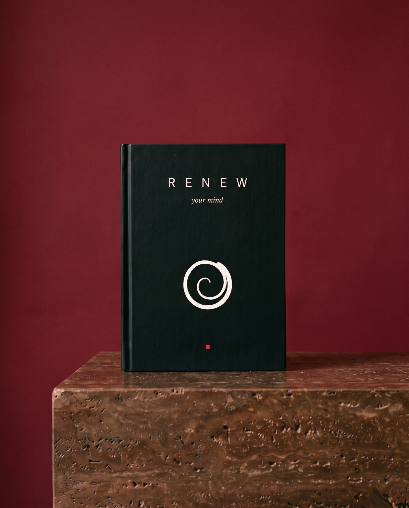 The black Renew your mind journal on dark stone